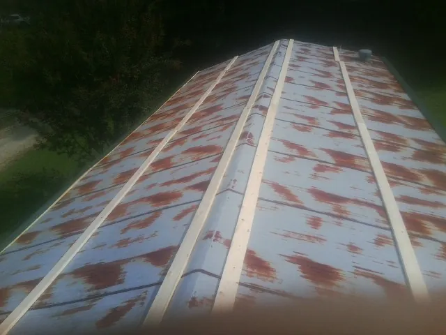 Rusted metal roof panels with new wood purlins before replacement — Storm Damage Roof Repair in Lyndora by Roofing Brothers