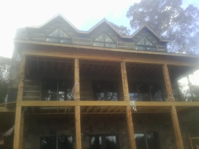 Dormers and porch framing on a large log home under construction — Roof Coating work by our crew in Lyndora