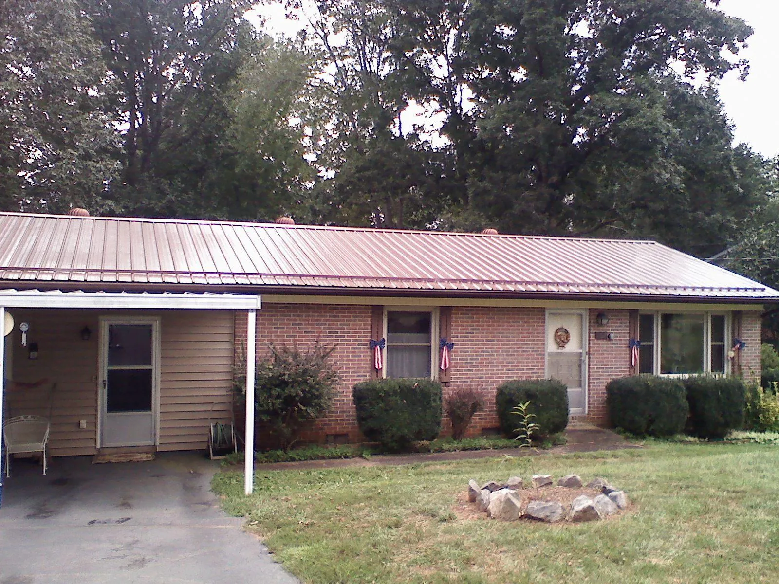 Bronze metal roof and carport on a brick ranch home — Roof Repair work by our crew in Lyndora